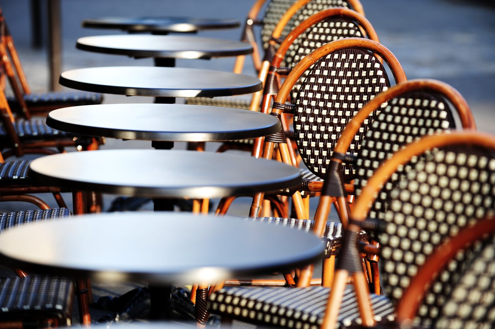 Bistro tables with round tops and rattan chairs